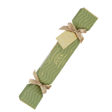 Single Luk Beautifood Guava Blush lip bonbon, a light green Christmas cracker with gold ribbon bows and a gift tag, shown diagonally on white. The packaging reads Soft Buttery Pink.
