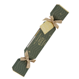 Single Luk Beautifood Rosé lip bonbon, a dark green patterned Christmas cracker with gold ribbon bows and a gift tag, shown diagonally on white. The packaging reads Flush of Rosé.
