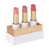 Luk Beautifood Lip Nourish Trio Buttery Pinks, with three uncapped pink lipsticks standing in a white presentation base with gold trim on a white background.