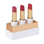 Luk Beautifood Lip Nourish Trio Luscious Reds, with three uncapped berry and red lipsticks standing in a white presentation base with gold trim on a white background.