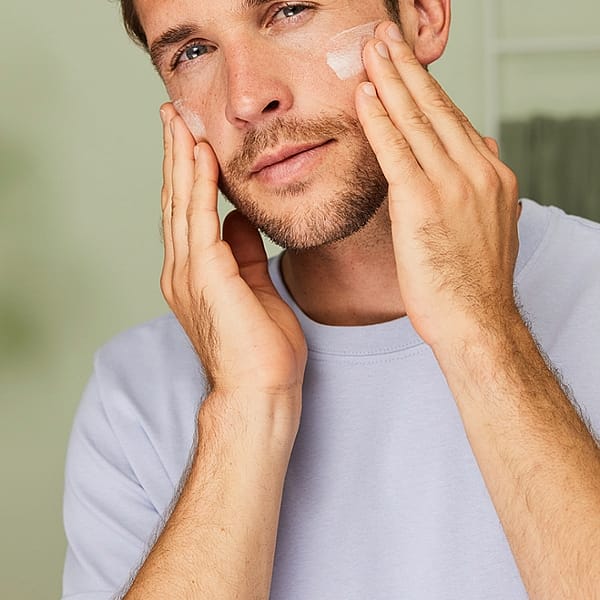 Man applying face cream to his face.