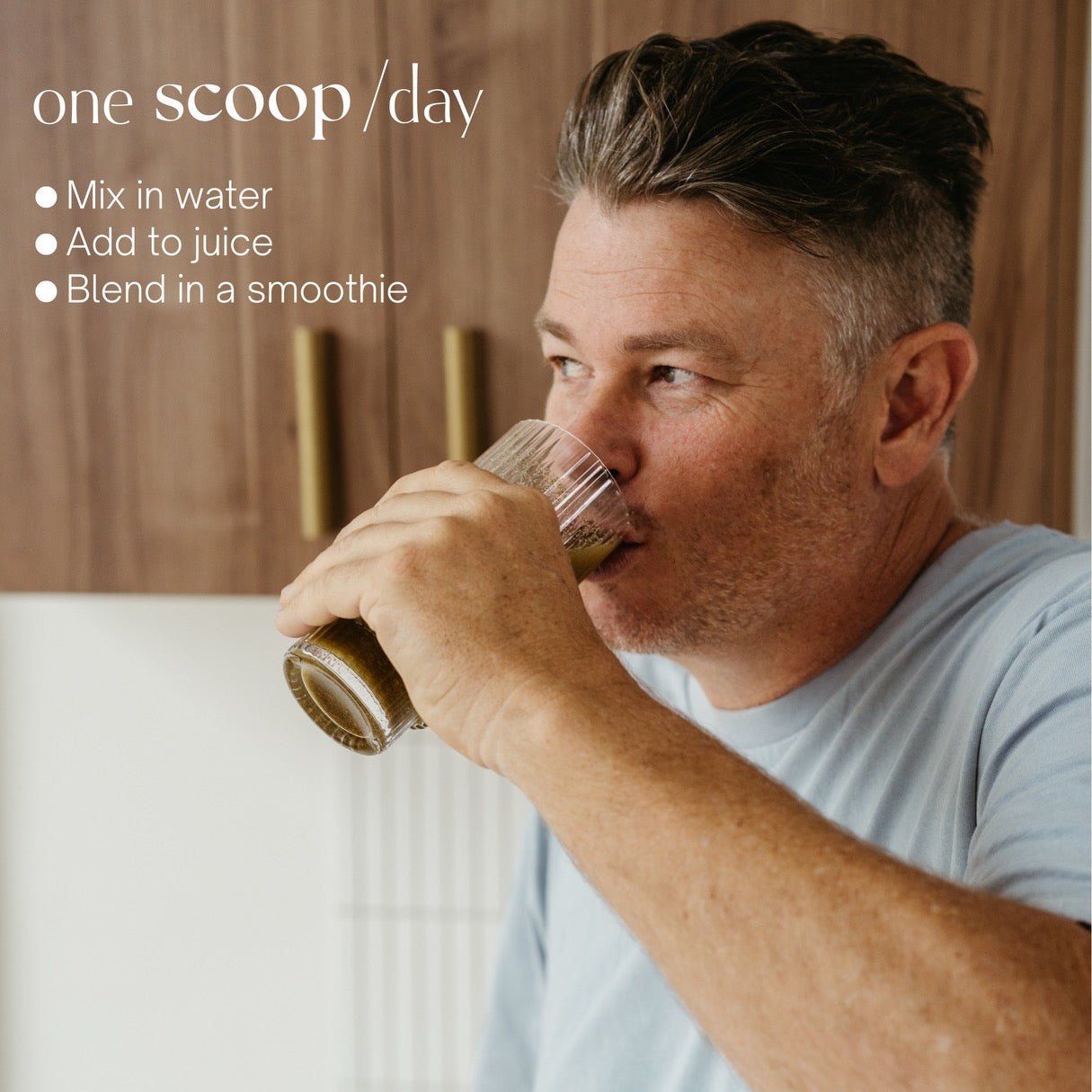 Man drinking a glass of Man21 in a kitchen