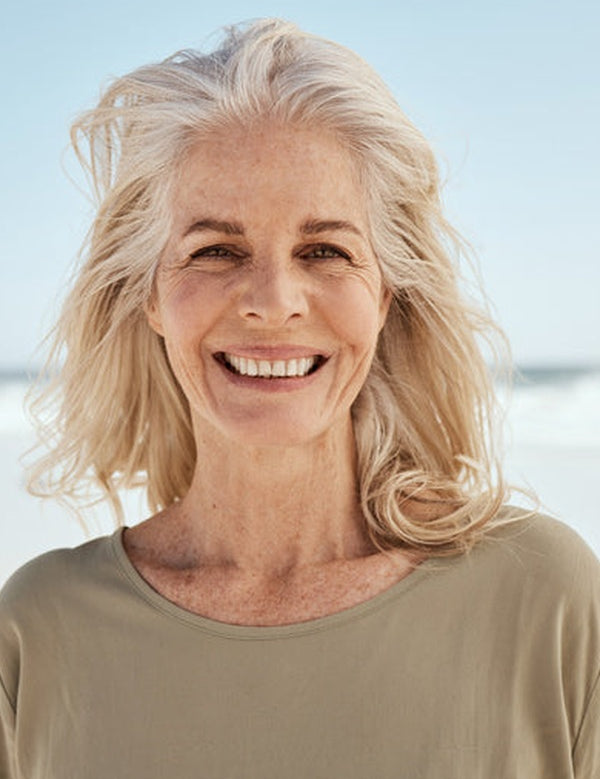 Smiling mature woman at the beach in official Melrose FutureLab Bone Matrix lifestyle imagery