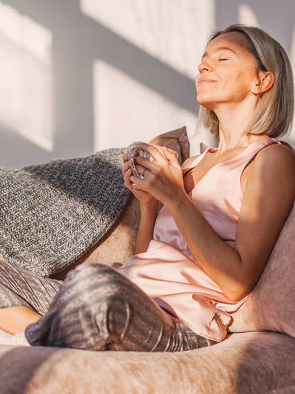 Woman relaxing with her cat in official Melrose FutureLab Deep Wave Sleep Booster lifestyle imagery