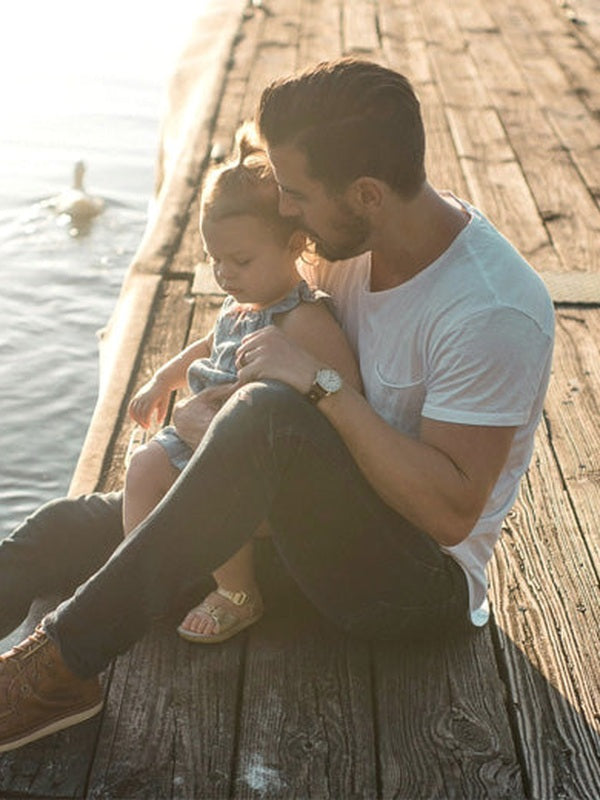 Father and child relaxing by the water in official Melrose FutureLab NAD Plus Booster lifestyle imagery