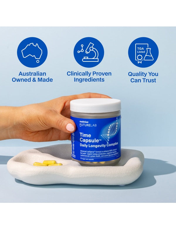 Hand holding Melrose FutureLab Time Capsule on a styled blue surface with capsules