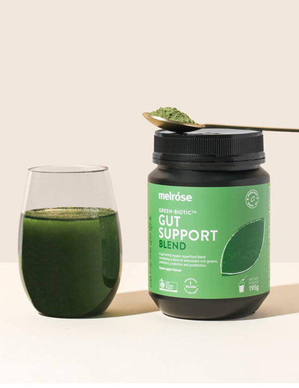 Melrose Green-Biotic Gut Support Blend styled with a prepared green drink and spoonful of powder.
