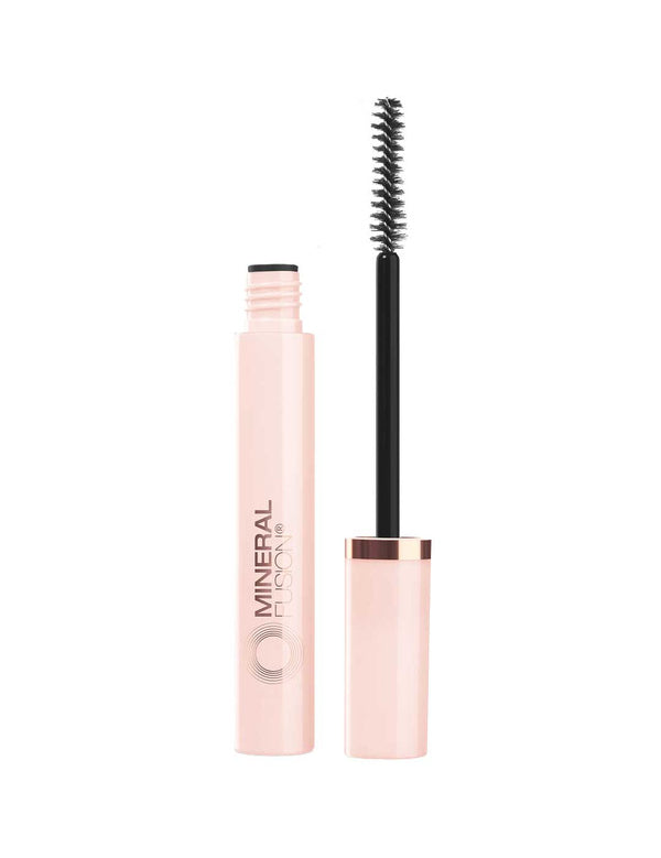 Open pale pink tube of Mineral Fusion So Ageless mascara in Black beside its upright wand, with a narrow spiral-bristled brush and a rose-gold band on the cap.