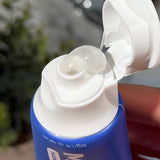 Clear gel toothpaste curling from an open blue MooGoo Kids Blueberry Smoothie Moothpaste tube held in a hand.