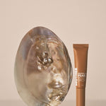 MOTHER SPF Mother of Pearl Bronzing Drops styled with a pearl shell
