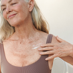 Woman applying Mukti Age Defiance Body Serum to her shoulder
