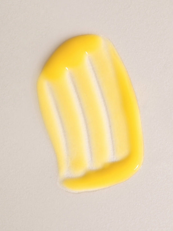 Glossy yellow swatch of Mukti Aloe Vera Moisturiser spread across a warm beige background.