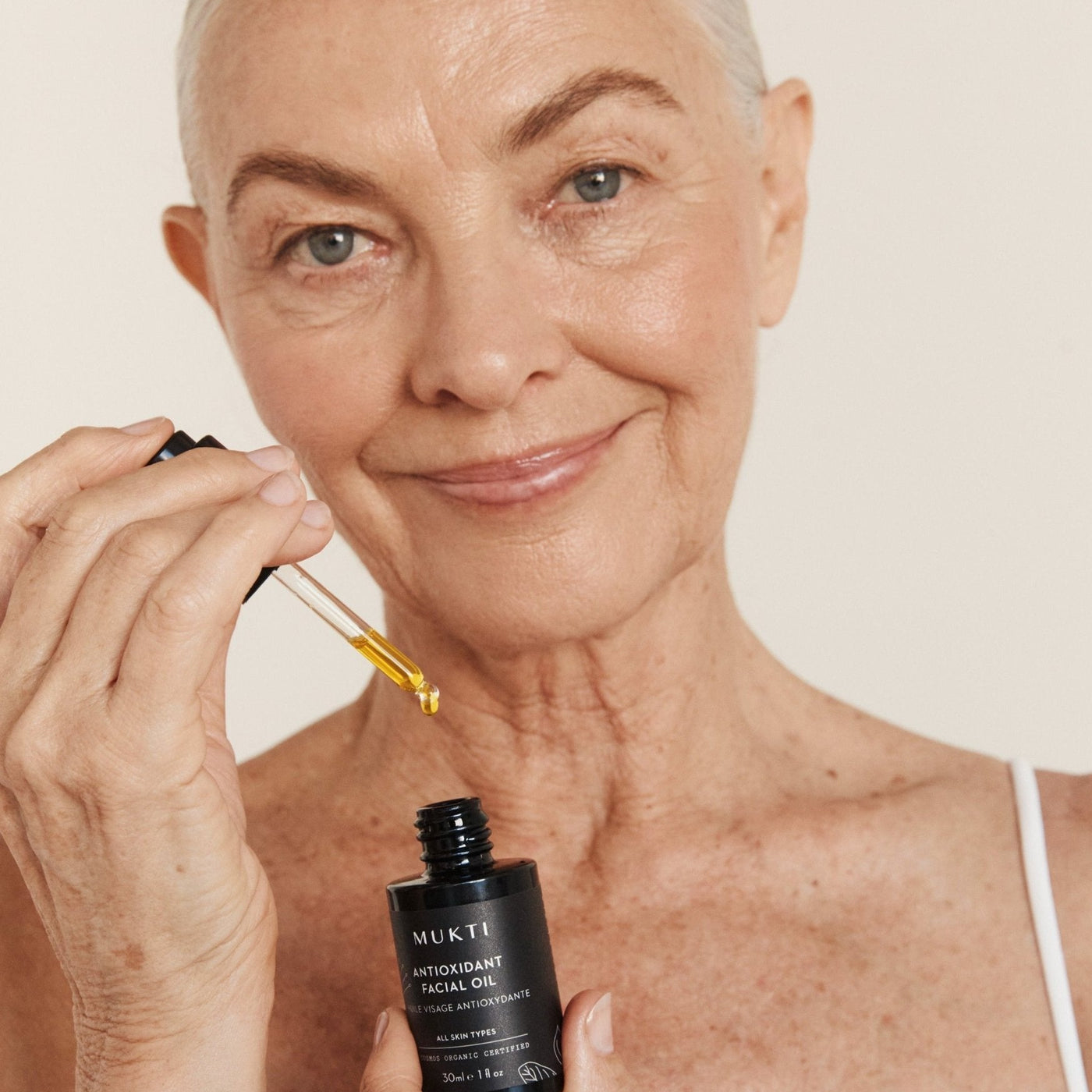 Woman applying Mukti Antioxidant Facial Oil