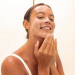 Woman cleansing her face with Mukti Balancing Cleansing Gel
