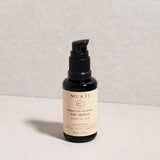 Mukti Bioactive Renewal Day Serum pump bottle styled on a light stone surface.