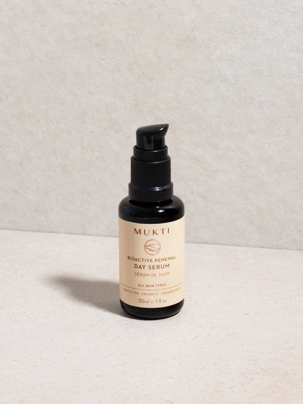 Mukti Bioactive Renewal Day Serum pump bottle styled on a light stone surface.