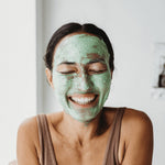 Smiling woman wearing Mukti Deep Cleanse Enzyme Mask