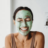 Smiling woman wearing Mukti Deep Cleanse Enzyme Mask
