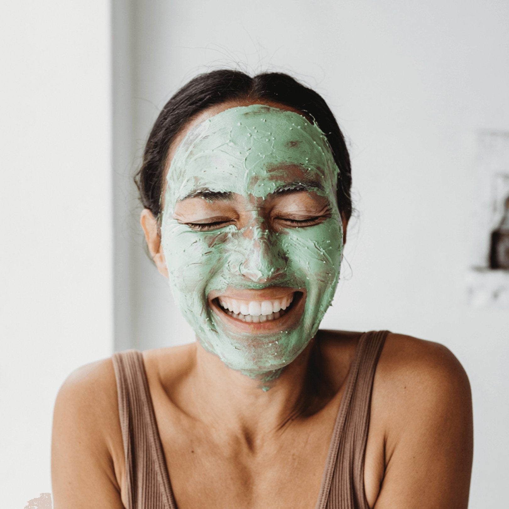 Smiling woman wearing Mukti Deep Cleanse Enzyme Mask
