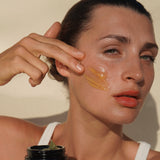 Woman applying Mukti Gentle Melt Cleansing Balm
