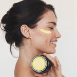 Woman holding Mukti Marigold Hydrating Creme to her neck