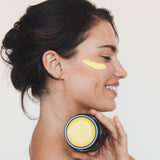 Woman holding Mukti Marigold Hydrating Creme to her neck
