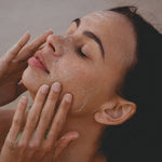 Woman relaxing with eyes closed while massaging Mukti 2-in-1 Resurfacing Exfoliant over her face.
