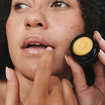 Woman applying Mukti Whipped Honey and Macadamia Lip Balm