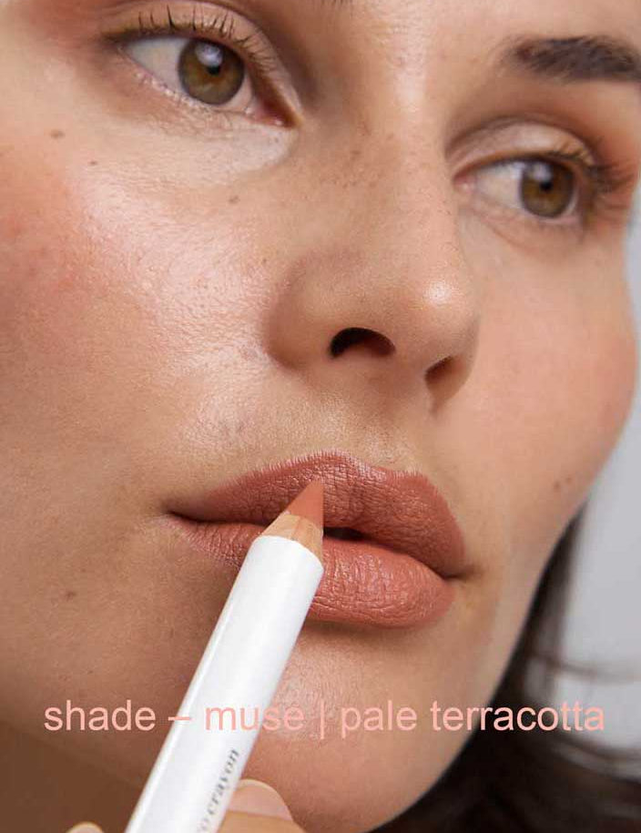 Close-up of a person holding a makeup pencil labeled 'shade - muse | pale terracotta'.