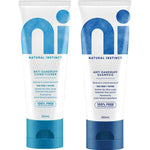 Two white Natural Instinct Anti-Dandruff tubes standing side by side: conditioner with turquoise lettering and cap, and shampoo with dark blue lettering and cap.