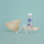 Noosa Basics Acne Spot Drying Lotion held while applying with a cotton bud