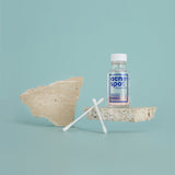 Noosa Basics Acne Spot Drying Lotion held while applying with a cotton bud