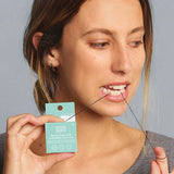 Woman using Noosa Basics bamboo charcoal dental floss