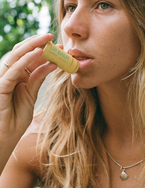 Woman applying Noosa Basics Chamomile Lip Balm
