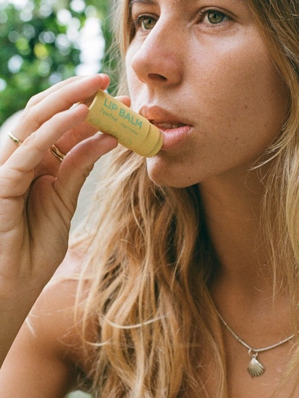 Woman applying Noosa Basics Chamomile Lip Balm