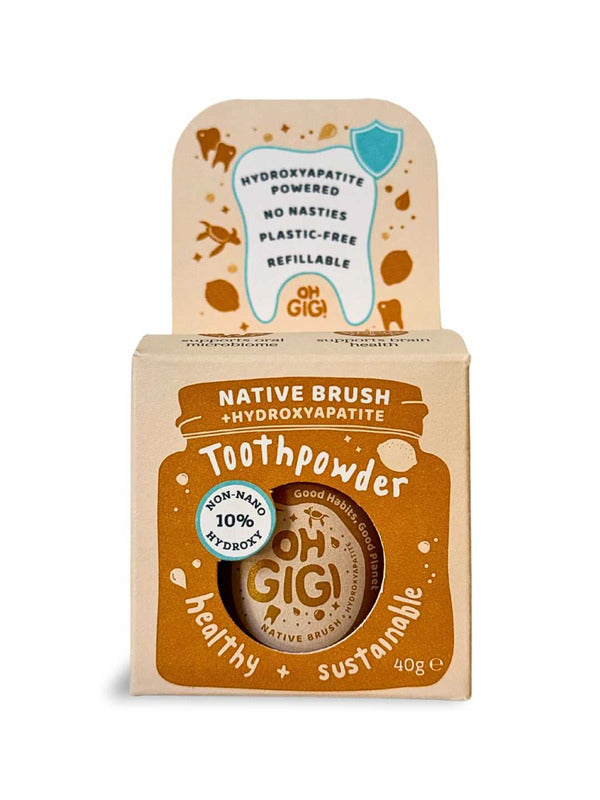 Kraft cardboard Oh Gigi Native Brush Toothpowder box with an ochre jar-shaped front panel and white lettering, topped by a tall tab decorated with a tooth outline and ochre botanical illustrations.