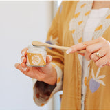Person using Oh Gigi Native Hydroxyapatite Tooth Powder with a bamboo toothbrush