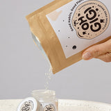 Oh Gigi Flavour-Free Hydroxyapatite Tooth Powder refill being poured into its glass jar