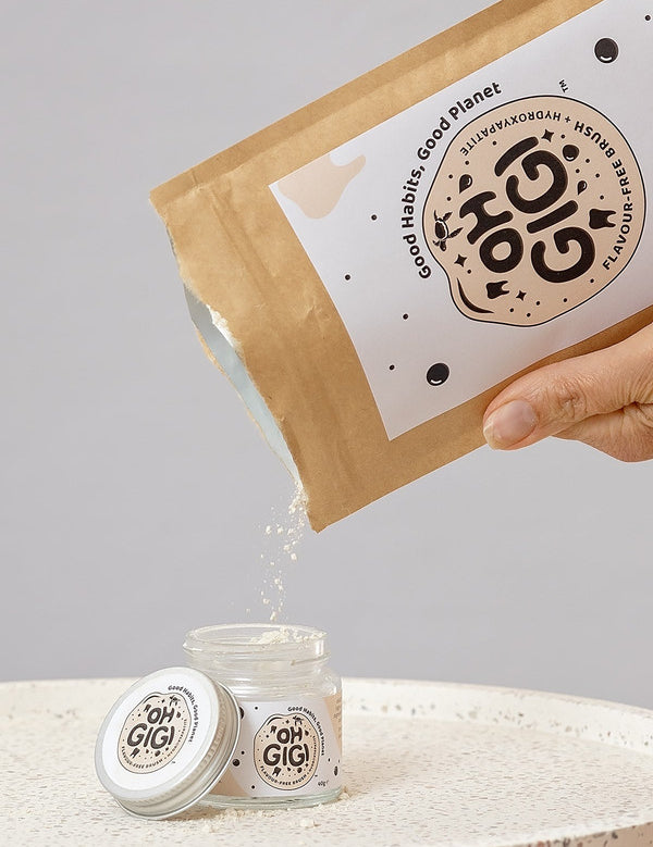 Oh Gigi Flavour-Free Hydroxyapatite Tooth Powder refill being poured into its glass jar