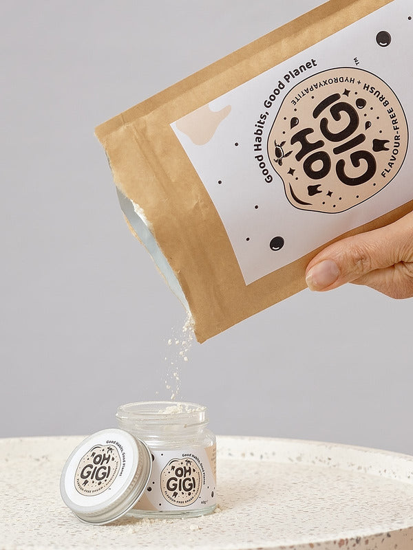 Oh Gigi Flavour-Free Hydroxyapatite Tooth Powder refill being poured into its glass jar