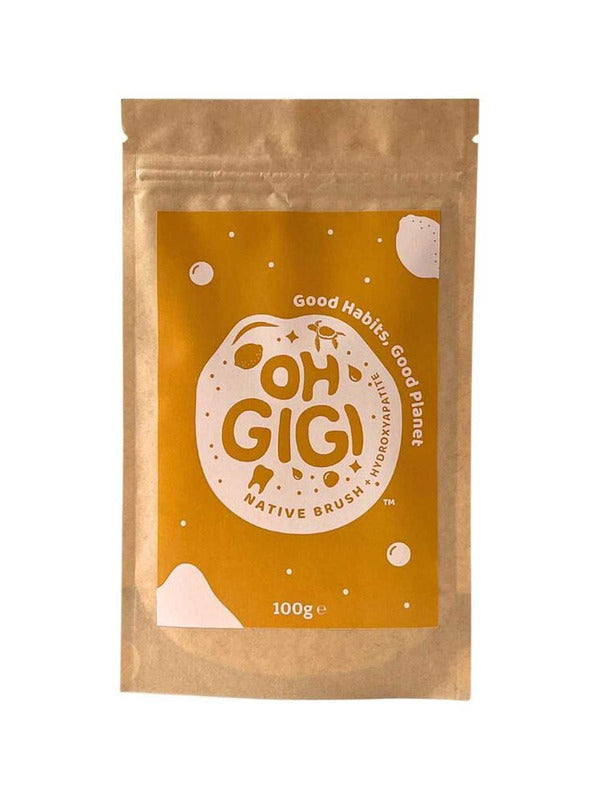 Brown resealable Oh Gigi Native Brush Toothpowder refill pouch with a large ochre label, bold lettering inside a cream circle, and scattered pale dots and shapes.