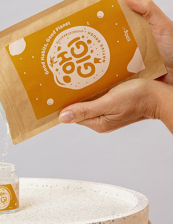 Oh Gigi Native Hydroxyapatite Tooth Powder refill being poured into its glass jar