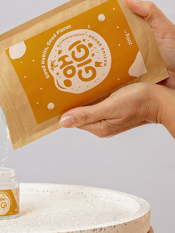 Oh Gigi Native Hydroxyapatite Tooth Powder refill being poured into its glass jar
