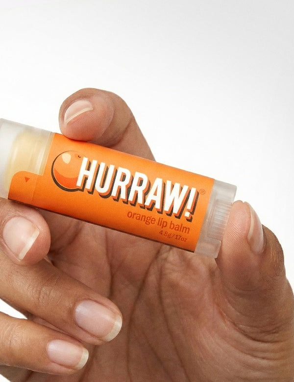 Hand holding Hurraw! Organic Lip Balm - Orange 4.8g