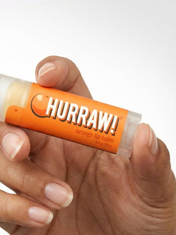 Hand holding Hurraw! Organic Lip Balm - Orange 4.8g