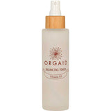 The Orgaid Balancing Niacinamide Toner 120ml comes in a clear frosted spray bottle with a wooden cap and floral logo, hydrating and balancing your skin with niacinamide for a refreshed feel.