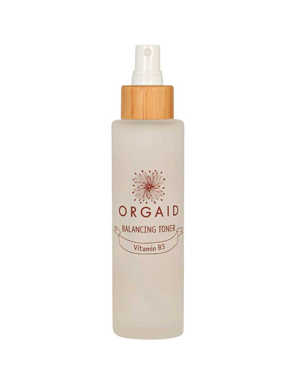 The Orgaid Balancing Niacinamide Toner 120ml comes in a clear frosted spray bottle with a wooden cap and floral logo, hydrating and balancing your skin with niacinamide for a refreshed feel.