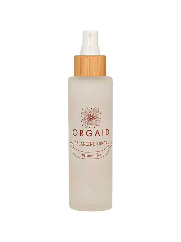 The Orgaid Balancing Niacinamide Toner 120ml comes in a clear frosted spray bottle with a wooden cap and floral logo, hydrating and balancing your skin with niacinamide for a refreshed feel.