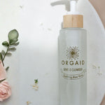 Orgaid Gentle Cleanser styled with flowers on a bathroom vanity