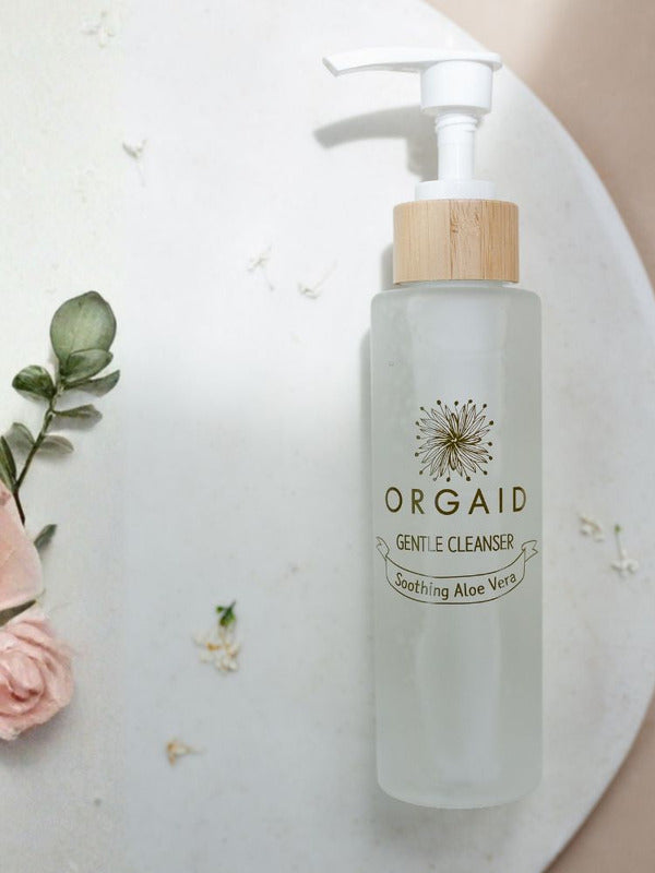 Orgaid Gentle Cleanser styled with flowers on a bathroom vanity